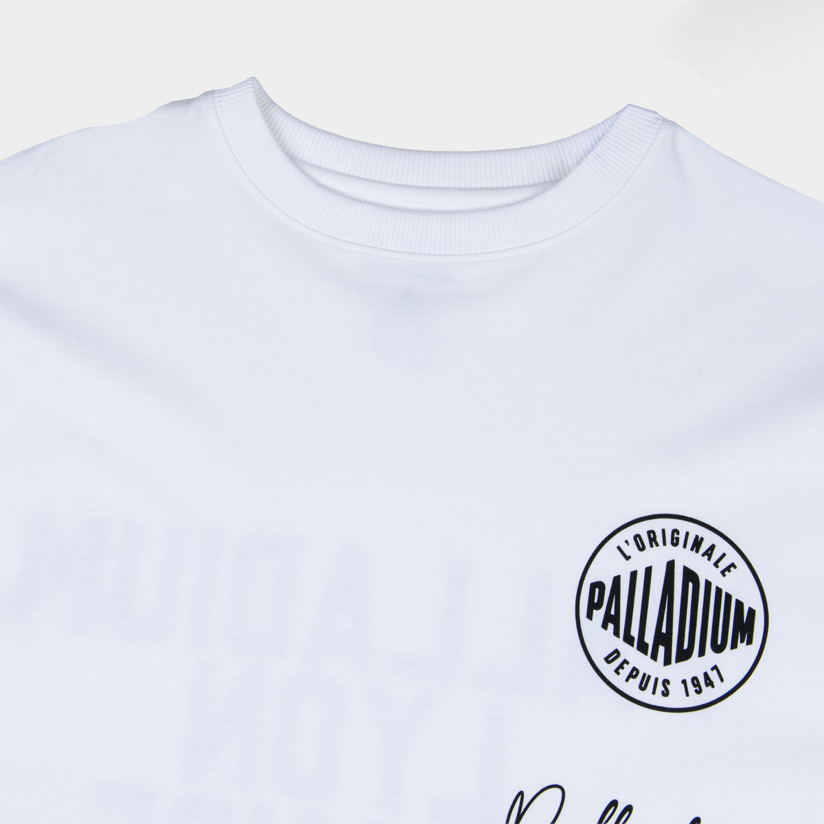 Close-up of Palladium L'Originale Depuis 1947 circular logo on Signature Oversized White T-Shirt