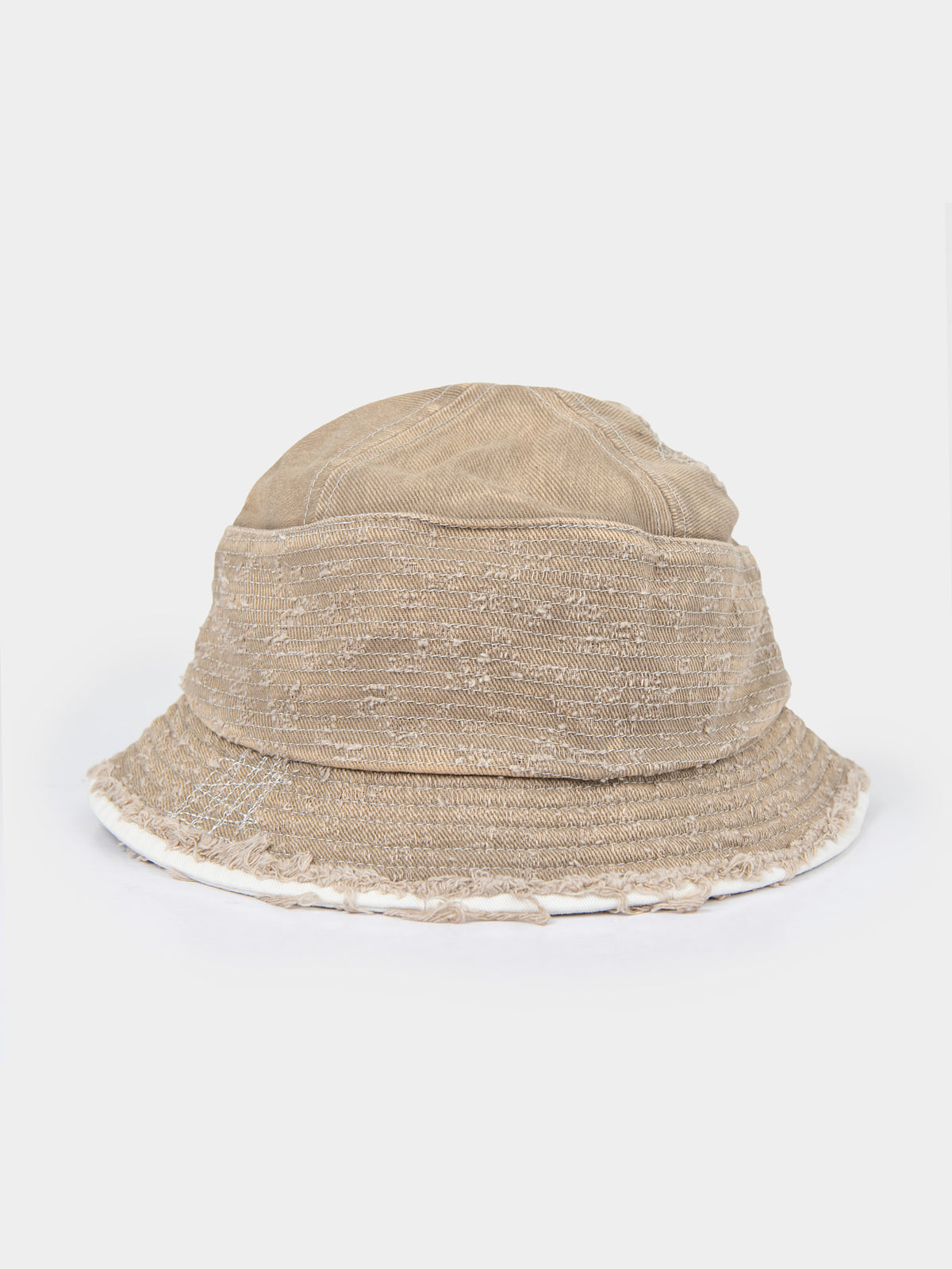 Palladium Frayed Bucket Hat in Stone beige distressed canvas with frayed raw-edge brim, side profile view