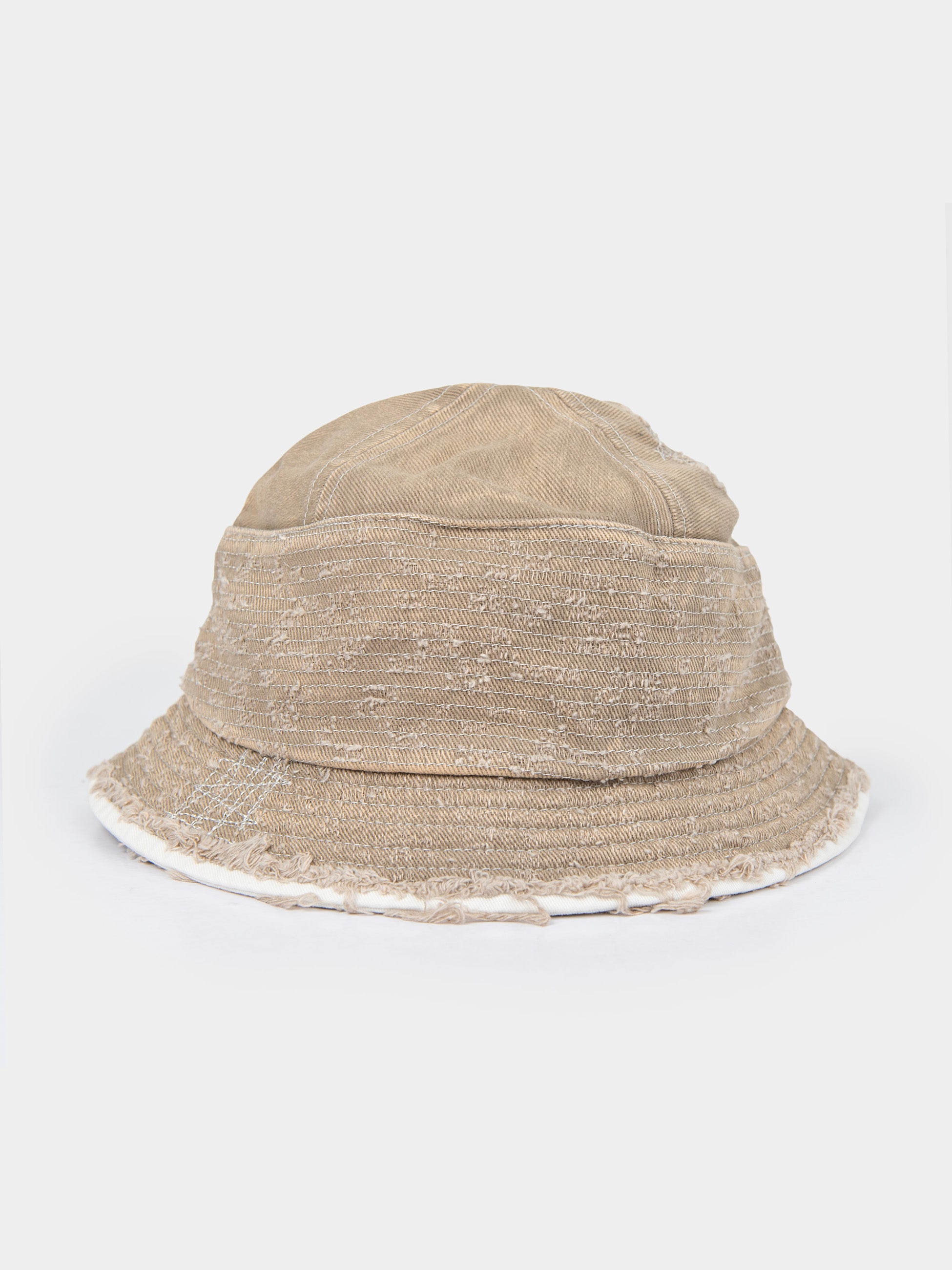 Palladium Frayed Bucket Hat in Stone beige distressed canvas with frayed raw-edge brim, side profile view